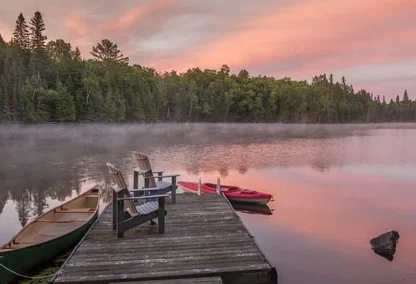Rowboats on a dock sitting on top of the lake in Haliburton Highlands with a sunset beaming over the waters